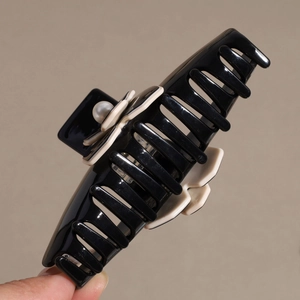 French camellia hair claw clip in black acetate with beige flower and pearl detail
