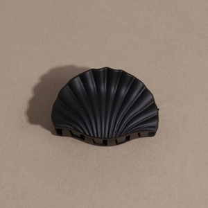 Close-up of matte black shell-shaped hair claw clip with multi-tooth grip and refined texture