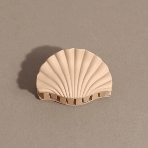 Close-up of elegant apricot shell shaped matte hair claw clip with smooth shark teeth detail