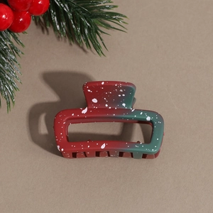 Macro shot of a matte Christmas flower hair claw clip with red and green gradients