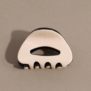 Detail view of the black and cream acetate hair claw with minimalist hollow design