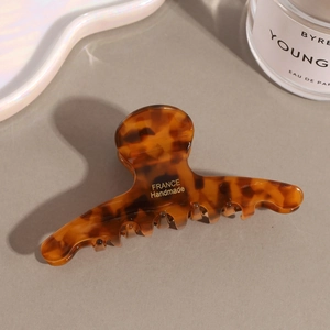 Detailed close-up of tortoise shell acetate hair claw clip with golden France Handmade logo