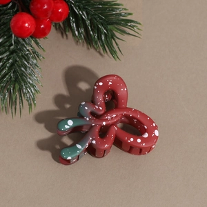 Close-up of red and green gradient Christmas hair claw clip with snow speckle finish