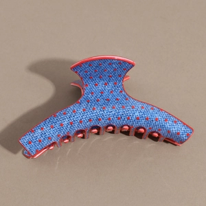 Detail of a denim texture hair claw clip featuring stylish red polka dots and firm teeth