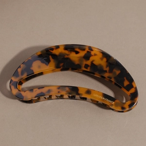 Detailed macro view of tortoiseshell crescent hair claw clip with Creation France logo