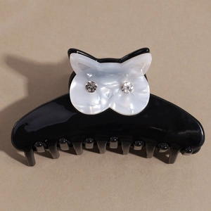 Elegant cat-shaped hair claw clip in black and white with sparkling rhinestone eyes