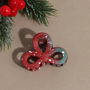 Detail showing Christmas floral hair claw with red and green gradient and snowflake dots