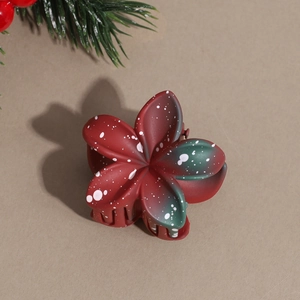 Detail of red and green gradient flower hair claw with festive white speckled finish