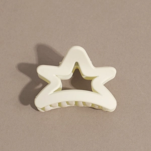 Close-up of cream star-shaped hair claw clip with matte finish and secure grip teeth