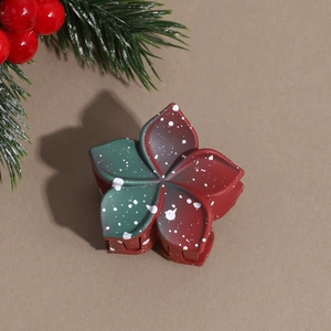 Detail of Christmas flower hair claw with red-green gradient and white snowflake pattern
