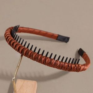 Detail view of brown satin headband with inner non-slip teeth on a display stand
