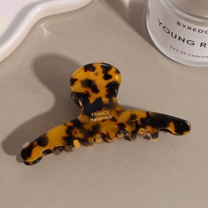 Close-up of tortoise shell acetate hair claw clip with gold France Handmade lettering