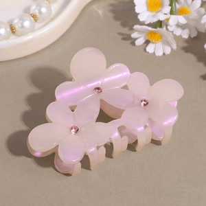 Detail view of pink floral hair claw clip with colorful pearlescent finish and sparkling rhinestones