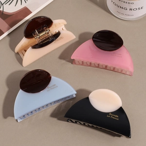 Elegant semi-round acetate hair claws in beige, pink, blue and black with logo detail