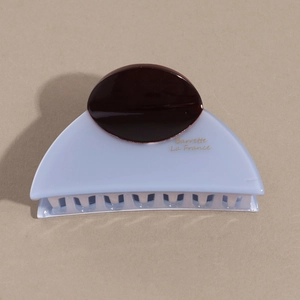 Detail of blue acetate hair claw clip with dark brown oval accent and comb teeth
