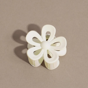 Macro detail of white matte flower hair claw clip with durable metal spring mechanism