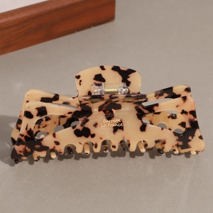 Detailed macro view of the dark leopard print acetate hair claw clip with golden spring