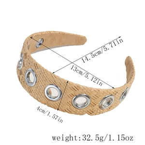 Handwoven raffia headband for women with silver eyelet accents on a white background