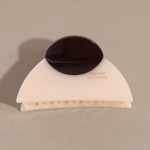 Detail of French style tortoiseshell hair claw with beige half-moon shape and brown disk