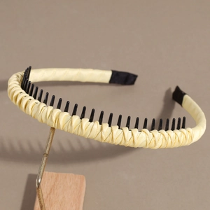 Close-up of light yellow fabric headband showing anti-slip teeth and woven texture