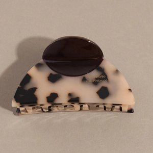 Detailed macro view of acetate hair claw with tortoise shell pattern and gold lettering