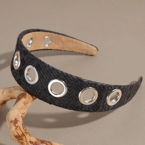 Close-up of black raffia woven headband with decorative silver metal eyelet grommets