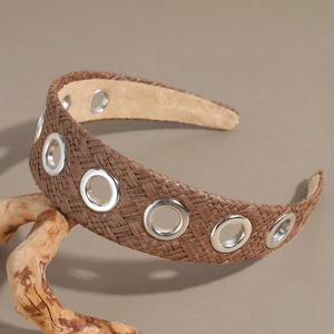 Close-up of brown raffia braided headband featuring decorative silver metal eyelets