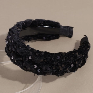 Detail of black braided velvet headband with sequins and high-top padded texture