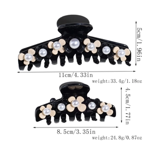 Detailed size comparison of large and small black floral hair claws with pearls