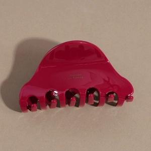 Detail of a magenta acetate hair claw clip featuring the golden Barrette La France text
