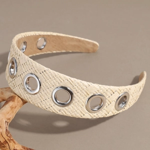 Detail of raffia woven headband featuring decorative silver metal eyelet accessories