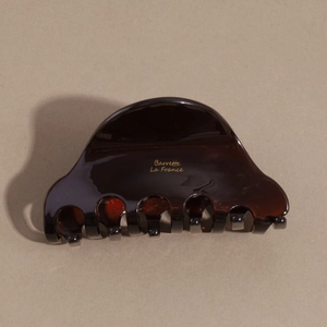 Close-up of tortoise shell hair claw clip featuring golden Barrette La France text
