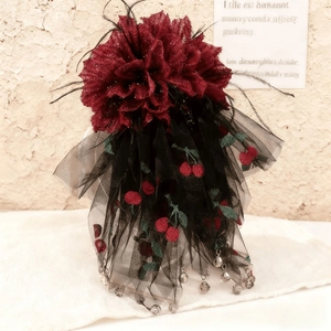 Vue détaillée de la pince à cheveux à fleurs en satin rouge avec broderie cerise et dentelle