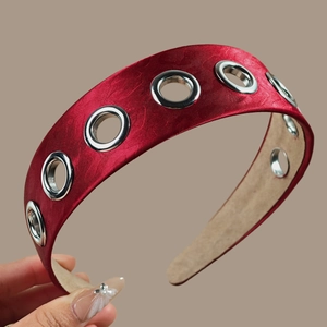 Detail of red satin headband featuring large silver metal eyelets and anti-slip lining