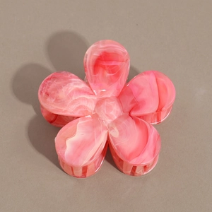 Vue détaillée de dessus de la pince à cheveux en forme de fleur avec motif marbré rose et blanc