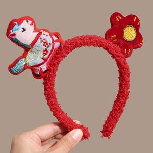 Detail of red fleece festive headband with gold embroidery and traditional red flower