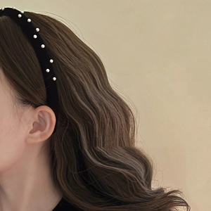 Elegant black velvet headband with white pearls for women showing side view on hair
