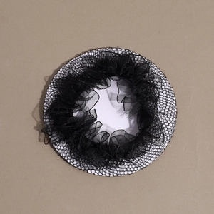 Detail view of black lace hair net with elastic ruffled edges on display card