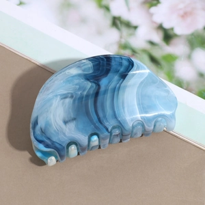 Detail of large marble pattern hair claw clip with gradient blue and white finish