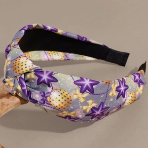 Detail of grey knotted headband with purple stars and golden festive patterns