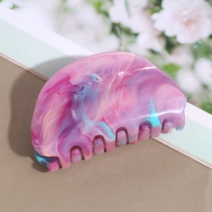 Close-up of a pink and blue marble pattern hair claw clip with a glossy acetate finish