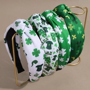 Green clover knot headbands set for St. Patrick's Day party on a gold display stand