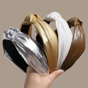 Set of four shiny faux leather knotted headbands in silver, gold, white and brown colors