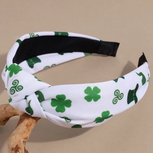 Close-up of St. Patrick's Day knotted headband with green shamrocks on white fabric