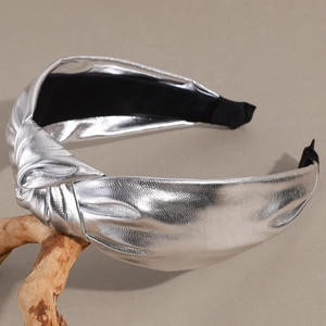 Detailed macro view of silver metallic knotted headband with premium lychee leather texture