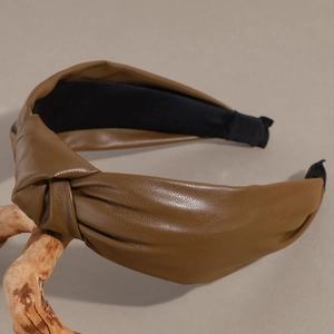 Detailed close-up of brown PU leather knotted headband with non-slip black inner lining