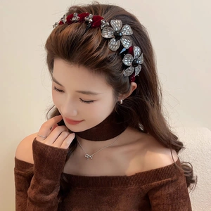 Elegant burgundy velvet headband with rhinestone flower patterns on a female model