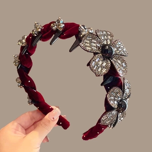 Detail view of burgundy velvet headband with crystal flower and anti-slip teeth