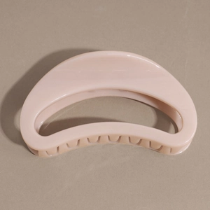 Détail d'une pince à cheveux demi-lune rose nude avec finition brillante et dents