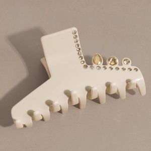 Detail of cream hair claw clip with rhinestones and elegant amber drop crystals